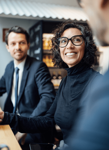 Ein Mann und eine Frau in Business Kleidung die in die Kamera lächeln